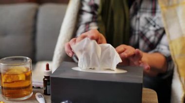 Yaşlı beyaz kadının elleri kağıt peçete alıyor. Bir fincan çay, bir kutu kağıt havlu. İçeride. Tedavi için. Hastalık..