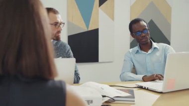 İş ekibi yeni projeleri tartışıyor. Ofiste dizüstü bilgisayar kullanıyor. RED Epic Camera 'da Çekim.