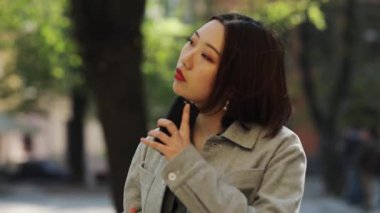 Sohbet telefonu kullanan genç Asyalı kadın gülümseyen sokak kızı Çinli kız alışverişi yapan Çinli mobil Asya cep telefonu işi gözü yavaş çekim yolluyor.