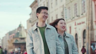 NEW YORK - 5 Nisan 2017: Asyalı genç çift birlikte yürüyüp gülümseyin şehir merkezinde mutlu olun iş kadını erkek erkeğe internet teknolojisi açık hava erkek şehir tarihi yavaş çekim portresi yakın çekim