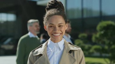 Gülümseyen güzel, şık, Afro-Amerikan iş kadını kameraya bakarken mutlu, kendinden emin. Kapatın. Yavaş çekim