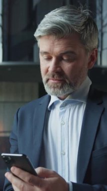 Akıllı, yakışıklı, beyaz iş adamının elinde akıllı bir telefonla mesaj okuduğu görüntüler. Kameraya bakan orta yaşlı, kendine güvenen bir adamın portresi. Restoran sahibi, takım elbiseli zarif biri.