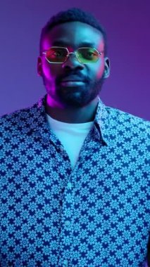 Şık bir adam kendine güveni tam bir şekilde ışık saçar, benzersiz modern tarzını ve cesur tavrını sergiler.