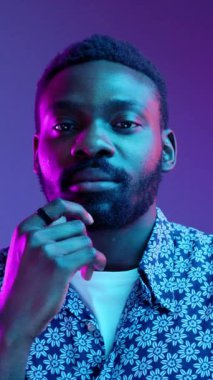 Düşünceli bir genç adam, modern tarzı ve derin düşünceleri yansıtan enerjik bir geçmişe karşı özgüvenle poz verir.