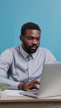 Dizüstü bilgisayarıyla yakından ilgilenen, çalışırken konsantrasyon ve verimlilik sergileyen bir profesyonel.