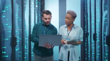 Çağdaş bir veri merkezi ortamında dizüstü bilgisayar kullanırken strateji oluşturan bir grup profesyonel.