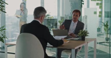 Yetişkin Kafkasyalı bin yıllık çalışan CV belgesini acemi yöneticiyle paylaşıyor, başarılı bir işe başvuruyor ve kurumsal ofiste iletişim kuruyor..