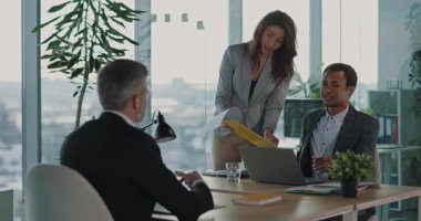 Çok ırklı erkek birkaç İK yöneticisi, iş için çalışan yetişkin bir işadamıyla gelecekte yapılacak işbirliği anlaşmasını tartışıyor. Ofis toplantısı.