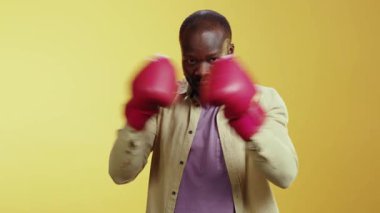 Videoda beyaz gömlekli ve mor kazaklı bir adamın sarı bir arka plana karşı durduğu görülüyor. Daha sonra kırmızı boks eldiveni giyer, dayanıklılık ve güven saçar.