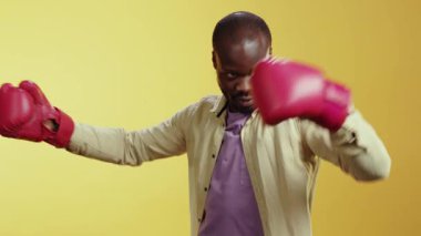 Dinamik bir video çeşitli senaryolarda bir adamı gösteriyor. Beyaz gömlekle başlar, kırmızı boks eldivenlerine geçer, ve keskin bir takım elbiseyle bitirir, zarafet ve ham güçle harmanlanır.