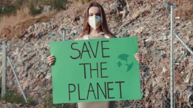 Tutkulu bir eylemci, önemli çevresel koruma ve farkındalığı ateşli bir şekilde savunan bir işaret tutar.