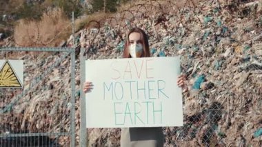 Kendini adamış bir insan, Doğa Ana 'nın kirlilikten korunmasını tutkuyla savunan çarpıcı bir işaret taşıyor.