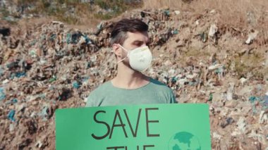 Çevresel farkındalığı protesto eden genç bir adam, güvenlik ve vurgu için maske takıyor.