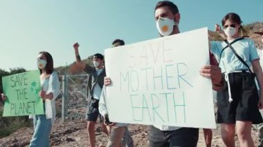 Eylemciler, iklim değişikliğinin farkındalığını savunan canlı işaretler taşıyarak Dünya 'mızı kurtarmak için bir araya geldiler.