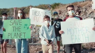 Kendini adamış bir grup genç aktivist acil çevre koruma ve iklim hareketi için tutkuyla gösteri yapıyor.