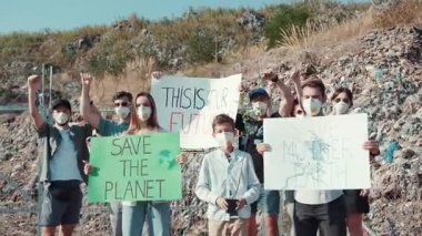 Gezegeni kurtarmayı protesto eden, işaretler tutan ve iklim hareketini savunan bir grup aktivist.