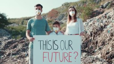 Şaşırtıcı bir doğal ortamda, birleşmiş bir aile gururla çevresel farkındalığı desteklemek için bir işaret tutar.