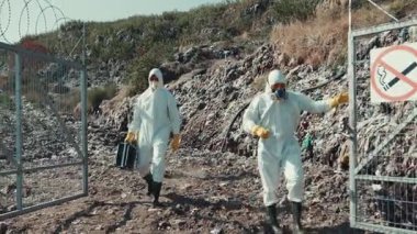 Koruyucu giysili bir ekip, bu işe karışan herkesin güvenliğini ve sağlığını sağlamak için atık yönetimi üzerinde çalışıyor.