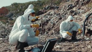 Koruyucu giysili bir ekip, çevresel araştırmalarda güvenliği sağlamak için doğal alandan örnekler topluyor..
