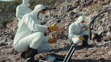 Koruyucu giysili bir ekip kirlenmiş bir bölgede çok tehlikeli bir madde temizliği yapıyor.