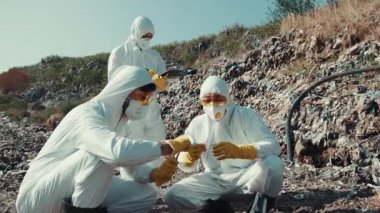 Koruyucu teçhizat donanımlı bir ekip analiz için iyileştirme alanında toplanan çeşitli örnekleri inceliyor.