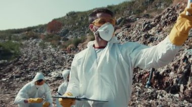 Koruyucu giysi giyen bir grup bilim adamı kıyı kirliliğini araştırıyor ve bunun çevresel etkisini değerlendiriyor.
