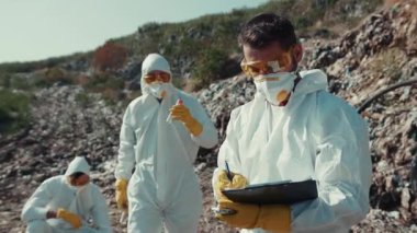 Koruyucu giysiler içindeki araştırmacılar tehlikeli ve kirlenmiş bir çevrede çok önemli veriler topluyorlar.