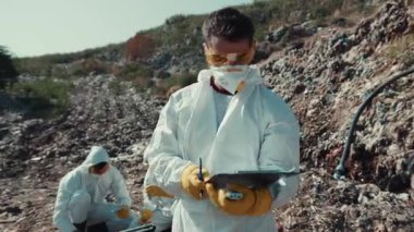 Yetenekli bir ekip, dışarıda bulunan tehlikeli maddeleri araştırıyor. Koruyucu giysiler ve maskeler giyiyorlar.