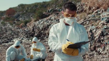 Koruyucu giysiler giyen uzmanlar, yoğun şekilde kirletilmiş bir bölgede, güvenlik önlemleri alınması için özenle araştırma yapıyorlar.