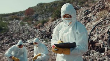 Koruyucu giysiler giyen bilim adamlarından oluşan bir ekip aktif olarak hayati çevre araştırmaları yürütüyor.