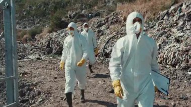 Koruyucu giysiler içinde özel bir tehlikeli madde ekibi kirlenmiş bir çevre üzerinde detaylı bir çalışma yürütüyor.