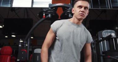 Spor salonlarında spor yapmaya çalışan yakışıklı genç adam spor yapmaya çalışıyor. Vücut gücü egzersizi. Sağlıklı erkek, sağlıklı atlet, genç kol modeli, beyaz dayanıklılık portresi.