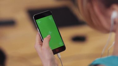 Kapat elini kadın spor kulübü spor salonu spor salonu kulaklığında dikey yeşil ekranlı telefon kullan cep telefonuna dokun dokunmatik ekranlı mobil spor salonu mobil uygulama monitörü internet cihazını aktif tut
