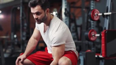 Spor salonundaki halterle egzersiz yapan çekici bir adam. Vücut gücü, sağlıklı, kaslı, sporcu, fiziksel, genç kol modeli, beyaz, dayanıklılık portresi. Yakından.