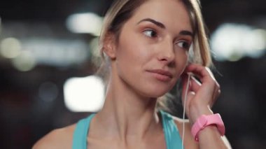 Yüzünüzü kapatın. Kulaklık takan genç bayan. Beden eğitimi portresi müziğini dinleyin.