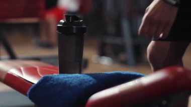 Kapalı el adam spor salonunda dinlenen şişe almak kamera yüz vücut çalıştırma spor spor genç erkek vücut geliştirme yakışıklı portre ağır çekim