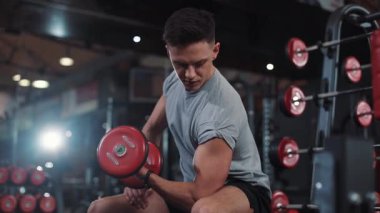 Spor salonundaki genç sporcu vücut gücü egzersizine uygun sağlıklı erkek, kaslı sporcu fiziksel kol modeli, Kafkas dayanıklılık portresi yakın plan.