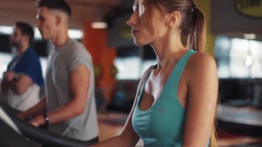 Spor salonundaki koşu bandındaki çekici genç kadın spor spor fitness İnternet yüz teknolojisi formda spor spor spor kıyafetleri vücut egzersizi akıllı telefon ağır çekim portresi