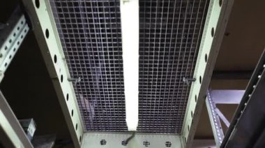 Bodrumdaki ışığı kapatın fabrika depoları makine iş ekipmanlarını geri çerçeveletin yavaş çekim inşaat lojistik ambalaj makinası endüstriyel kutu işi