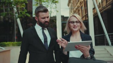 İşadamı ve kadın kapalı gidin ve tablet bilgisayar kullanın açık havada sohbet yakışıklı internet teknolojisi çift şirket yönetim şehir dışında genç takım çalışması