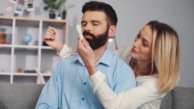 Neşeli bir çift, keyifli ve neşeli bir anı paylaşırken biri diğerinin gözlerini sevgiyle kapatıyor.