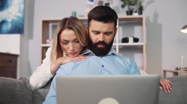 Sevgi dolu bir çift, rahat evlerinde dizüstü bilgisayarlarıyla iş birliği yaparken özel bir andan zevk alır.