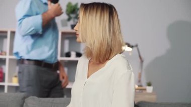 Düşünceli bir kadın şık bir oturma odasında rahatça oturur, pozitif titreşimler yayar ve rahatlar.