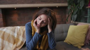 Sağlıksız üzgün kadın kameraya bakıyor. Hapşıran baş ağrısı öksürüğü. Kanepe virüsü kapmış, kendini hasta hissediyor.