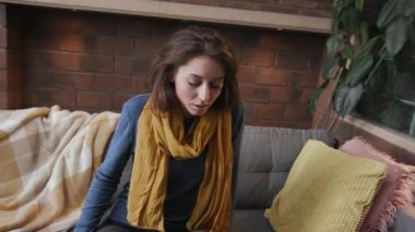 Kapalı kadının başı kanepede şiş, hasta, mutsuz, kadın semptomları sağlıksız, genç, sağlıksız, ilaç hapları ağır çekimde acı diye bağırıyor.