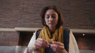 Yakından bir kadın ölçer, sıcaklığı ölçer, gülümser, kanepede oturur, çay içer, evde oturur, grip olur, soğuk algınlığı geçirir, hastalık kapar, virüs kapar, ağır çekimde haplar.