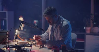 Kafkasyalı Yetişkin Mühendis, Çağdaş Laboratuvar Araştırma Merkezi 'nin içinde Bozuk İnsansız Hava Aracı Tamir Ediyor. Karanlık İçişleri. Elektronik için kavram.