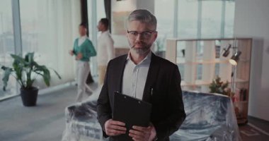 Kendine güvenen ve yetenekli bir profesyonel duruş modern bir ofis alanında etkili bir liderliği temsil ediyor.