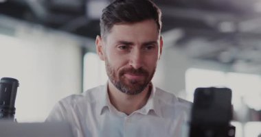 Neşeli Kafkasyalı çekici bir yetişkin cep telefonu kullanıyor çevrimiçi takipçilerle video yayınları kaydediyor..