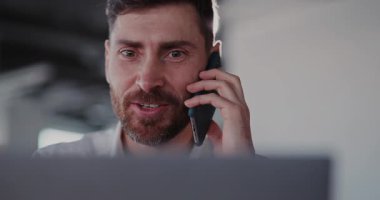 Modern bir çalışma alanının dinamiklerini ve etkili iletişim uygulamalarını özetleyen bir telefon görüşmesi yapan bir adam.